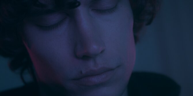 Jeune homme aux yeux clos dans une lumière violette douce, gros plan – clip Faubourg & Rith Banney Lost