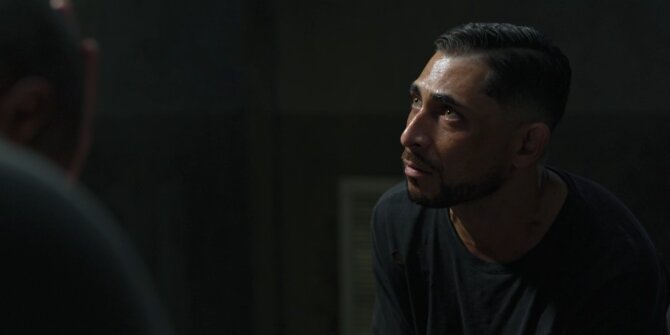 Homme levant les yeux dans une salle d'interrogatoire sombre, lumière latérale – OPJ saison 4 Bianca